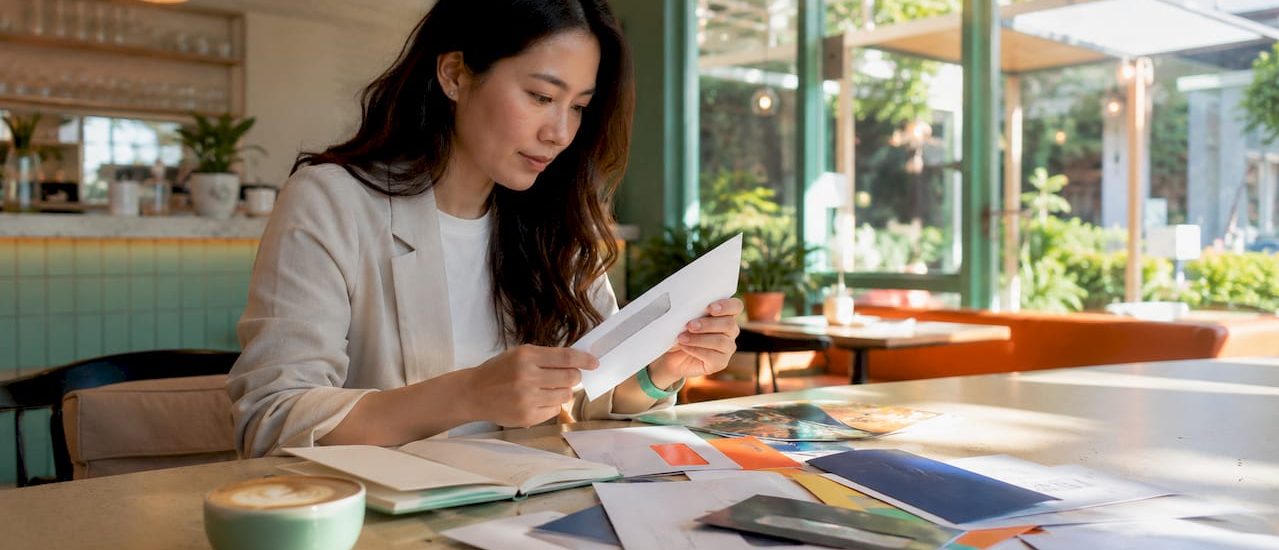Person sorting teaser ad mailers at desk